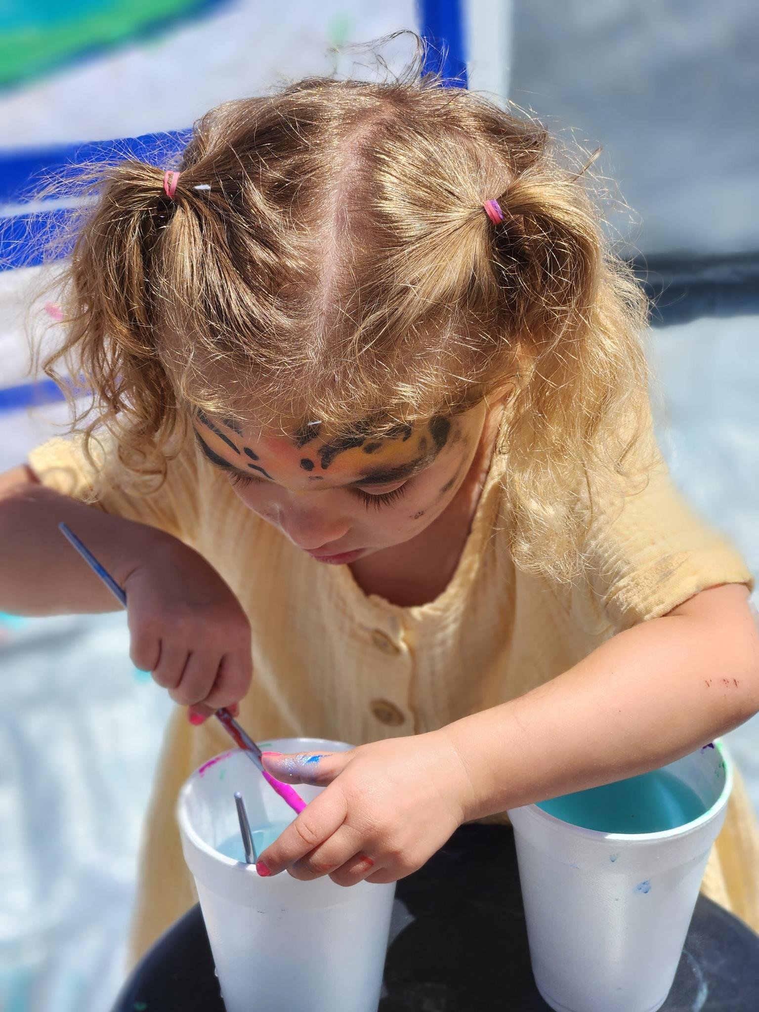 Girl painting colorful cups